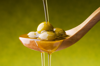 Frische grüne Oliven in goldenem Olivenöl – Sinnbild mediterraner Küche und das flüssige Gold Italiens.