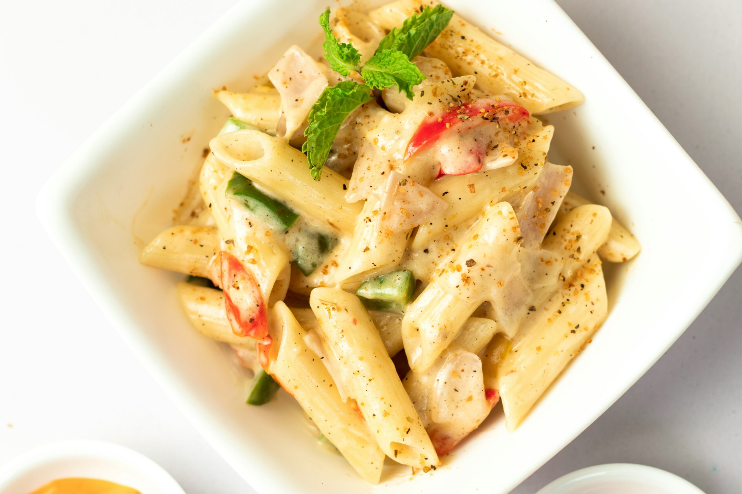 Frische Penne in cremiger Sauce mit buntem Gemüse, verfeinert mit Gewürzen und einem Hauch Minze – Genuss pur.